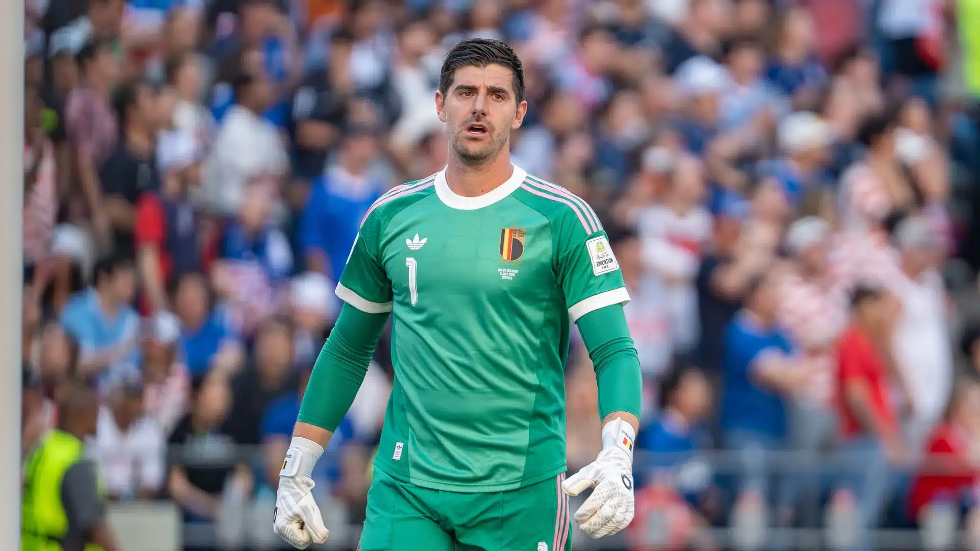 Thibaut Courtois wearing a green Belgium national team goalkeeper kit during a match.